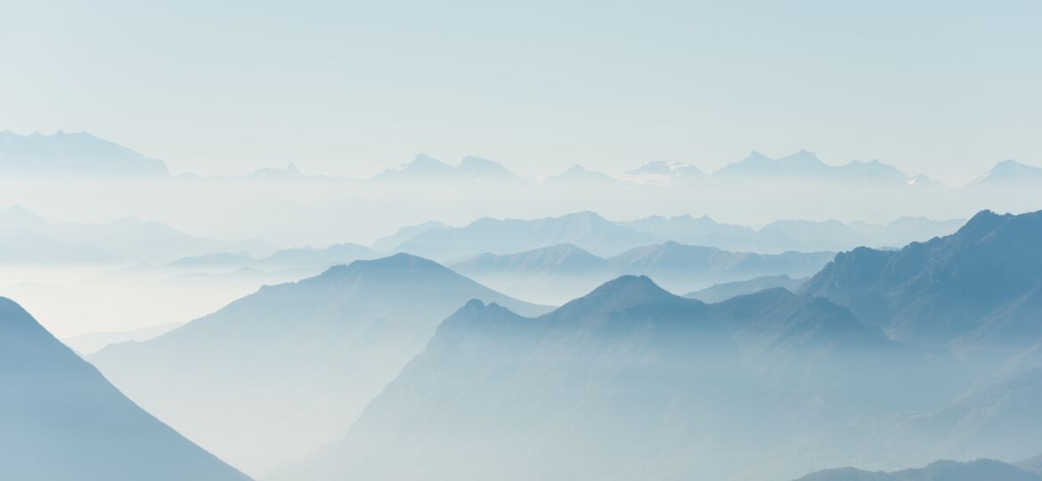 Beautiful shot of high white hilltops and mountains covered in fog